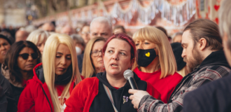 Person speaks into microphone amongst group