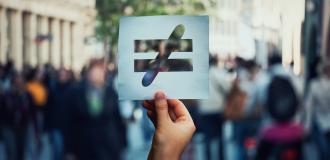 a hand holding a symbol for equality and the end of discrimination 