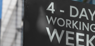 Banner featuring a sign with text on saying "4 Day Working Week"