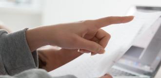 A person pointing at a piece of paper