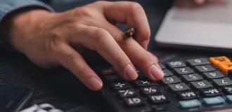 Hand typing on a calculator