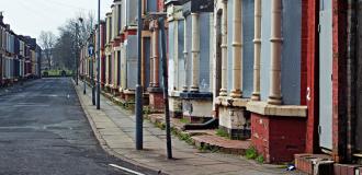 A row of Georgian-style houses, boarded up waiting for regeneration