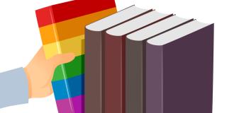 A white hand taking a rainbow-coloured book from a stack of neutral coloured books.