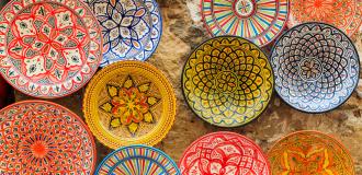 A photo of various colourful patterned dishes photographed from above. They have geometric patterns in different colours