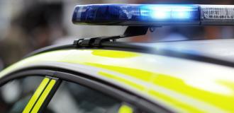 a close up of a British police car with blue flashing lights. 