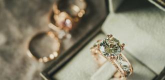 An antique diamond ring in an intricate jewellery box. There are 2 more rings in the background of the image