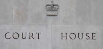 A stone wall with a crown and the words "Court House" engraved into it.