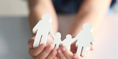 child holding a cut-out family in hand