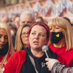 Person speaks into microphone amongst group