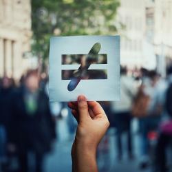 a hand holding a symbol for equality and the end of discrimination 