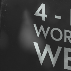 Banner featuring a sign with text on saying "4 Day Working Week"