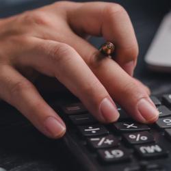 Hand typing on a calculator