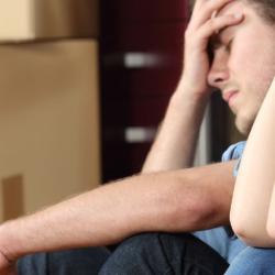 Distressed man and women surround by boxes 