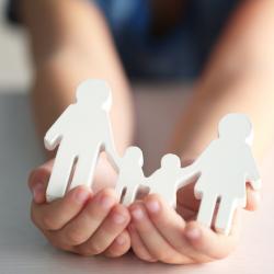 child holding a cut-out family in hand