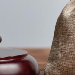 A gavel and a hessian bag with a dollar sign on a wooden table.