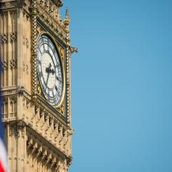 Big Ben against a clear blue sky with a union flag in the left corner