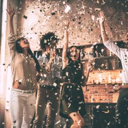 A group of people celebrates with confetti.