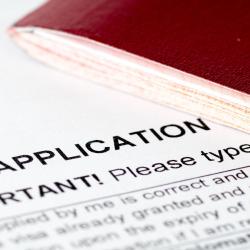 A photo of a British visa application and a maroon passport.