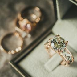 An antique diamond ring in an intricate jewellery box. There are 2 more rings in the background of the image