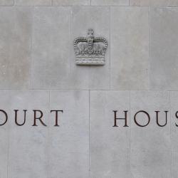 A stone wall with a crown and the words "Court House" engraved into it.